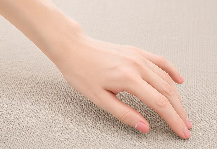 Close detail of a companion hand touching a fabric surface