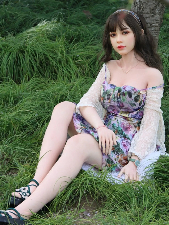 金山薇薇 164公分 AI陪伴型智慧人形，穿著碎花洋裝坐在草地上，展現精緻觸感和外觀。