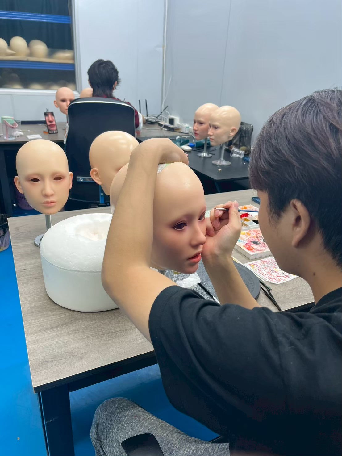 Craftsperson applying facial detail by hand
